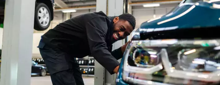 Smiling man fixing car